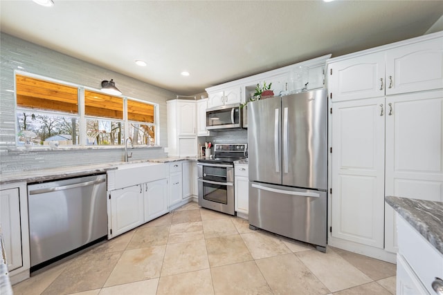 kitchen featuring appliances with stainless steel finishes, white cabinetry, and light tile patterned floors