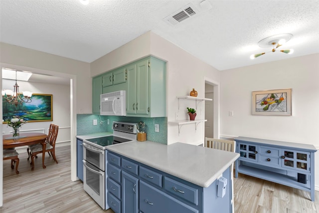 kitchen with an inviting chandelier, a textured ceiling, double oven range, light hardwood / wood-style floors, and backsplash