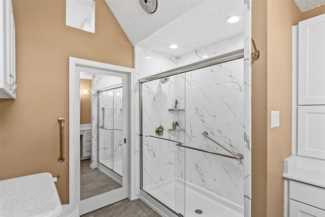 bathroom featuring vanity, an enclosed shower, and a textured ceiling