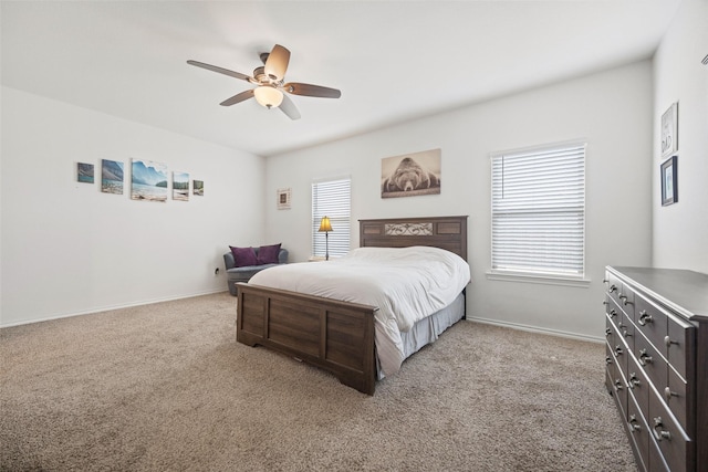 bedroom with ceiling fan, multiple windows, and light carpet