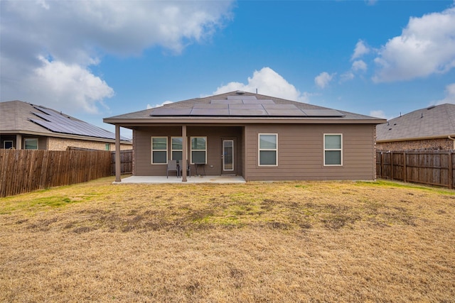 back of house with a lawn, solar panels, and a patio area