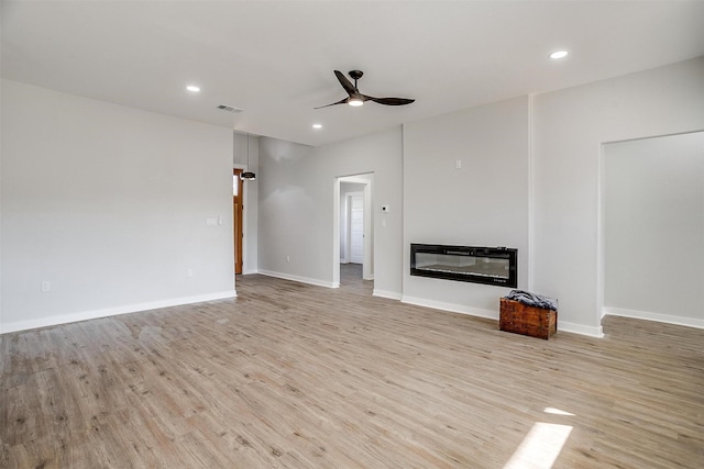 unfurnished living room with ceiling fan and light hardwood / wood-style floors