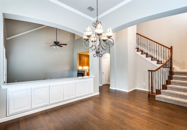 interior space featuring crown molding, lofted ceiling, dark hardwood / wood-style flooring, and ceiling fan with notable chandelier