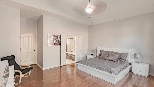 bedroom featuring wood-type flooring, ceiling fan, and ensuite bath