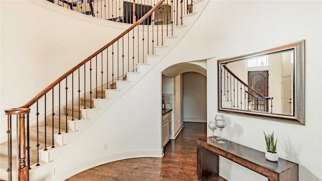 staircase featuring hardwood / wood-style floors and a high ceiling