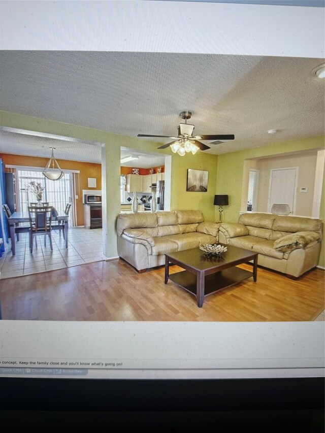 901 Mulder, Arlington, TX 76001 - living room with ceiling fan, hardwood / wood-style floors, and a textured ceiling