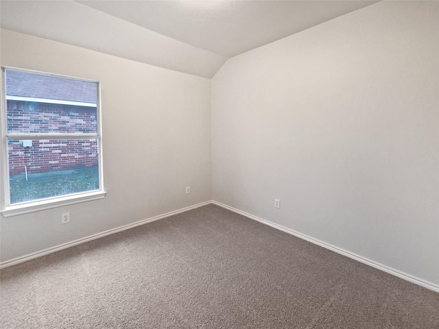 unfurnished room with lofted ceiling and carpet flooring