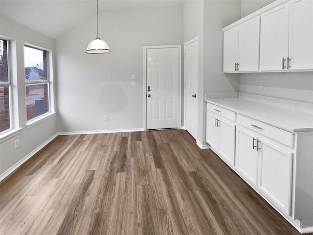 unfurnished dining area with dark hardwood / wood-style flooring and vaulted ceiling