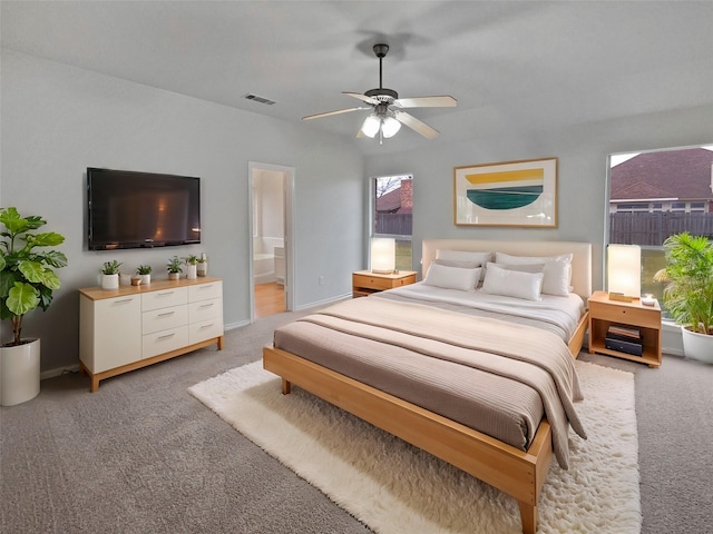 carpeted bedroom featuring ceiling fan and ensuite bath