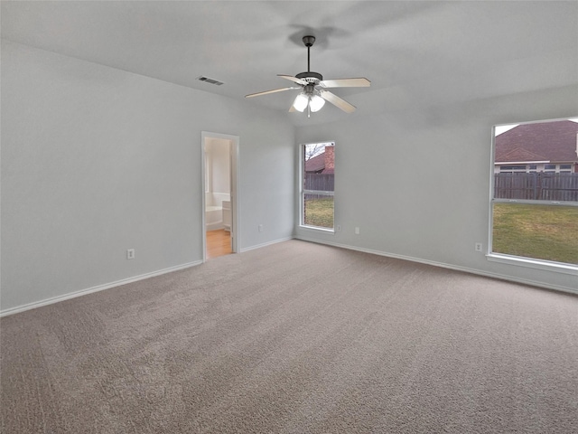 carpeted empty room with ceiling fan and a healthy amount of sunlight