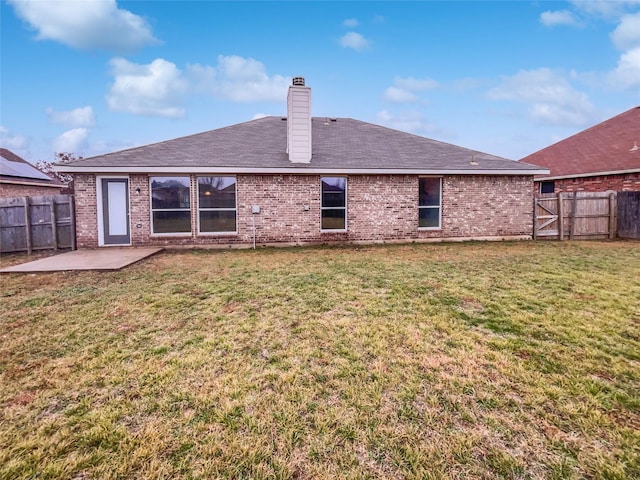 rear view of property featuring a patio area and a lawn