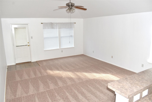 carpeted spare room featuring ceiling fan