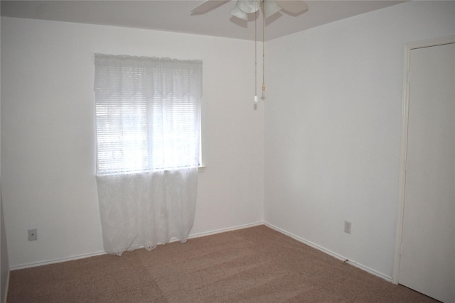 carpeted spare room featuring ceiling fan