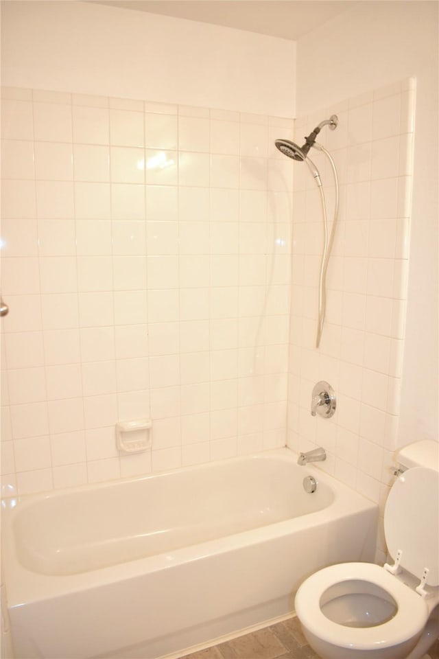 bathroom with toilet and tiled shower / bath