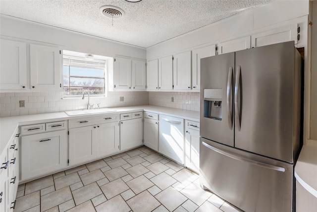 kitchen featuring sink, white cabinets, and stainless steel fridge with ice dispenser