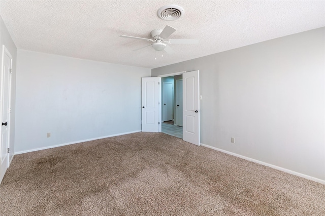 unfurnished room with a textured ceiling, ceiling fan, and carpet flooring