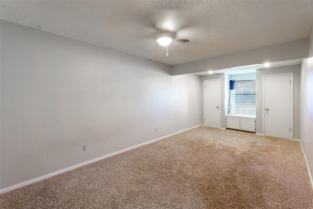 carpeted spare room with ceiling fan and a textured ceiling