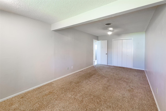 unfurnished room featuring carpet floors and a textured ceiling