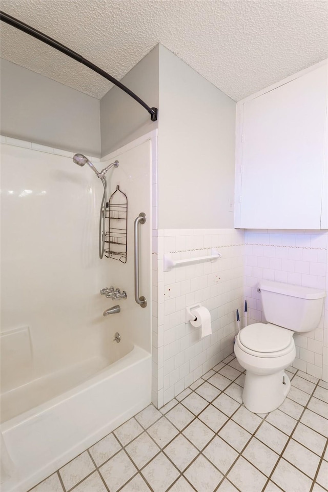 bathroom featuring shower / tub combination, tile patterned floors, toilet, and a textured ceiling