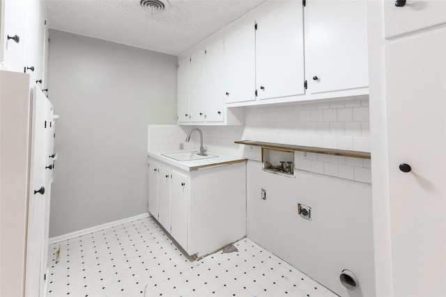 laundry room with sink, electric dryer hookup, cabinets, washer hookup, and a textured ceiling