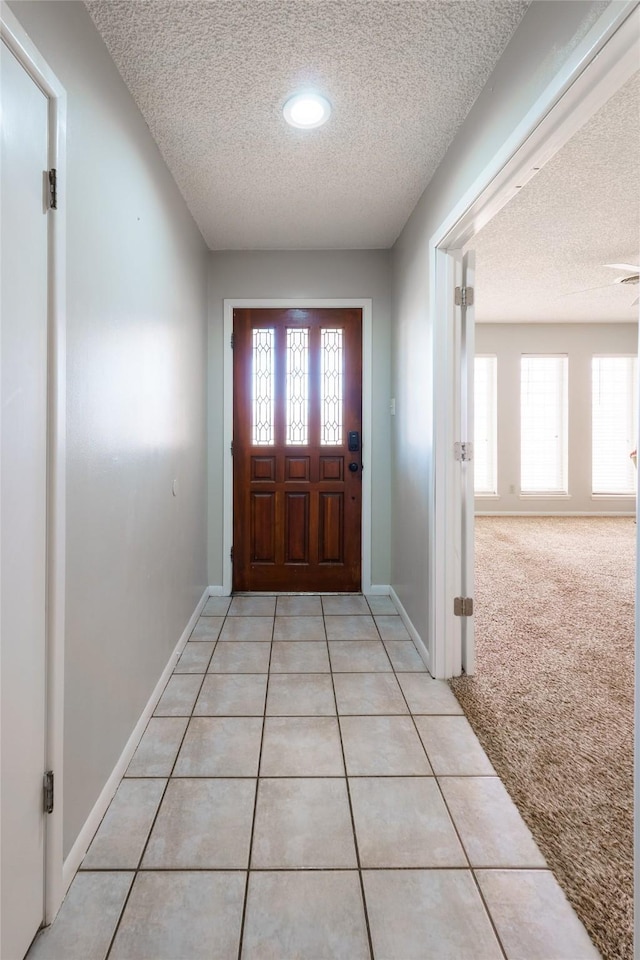 carpeted entryway featuring a textured ceiling and a healthy amount of sunlight