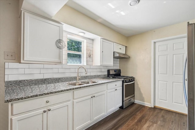 kitchen featuring sink, stainless steel appliances, dark stone counters, and white cabinets