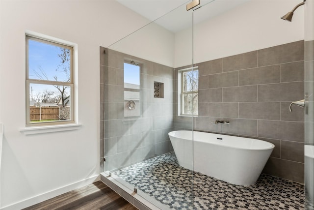 bathroom featuring hardwood / wood-style flooring, tile walls, and a tub