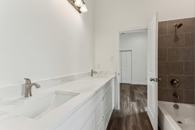 bathroom featuring vanity, wood-type flooring, and tiled shower / bath