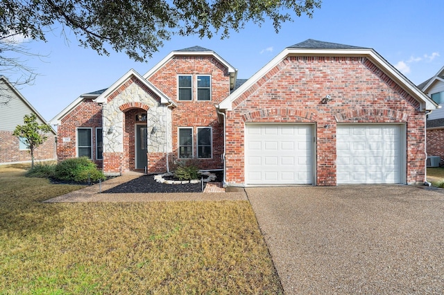 front facade featuring a garage, a front yard, and central air condition unit