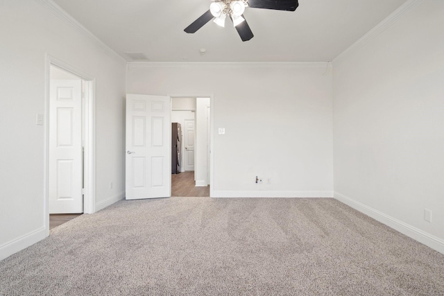 carpeted spare room with crown molding and ceiling fan