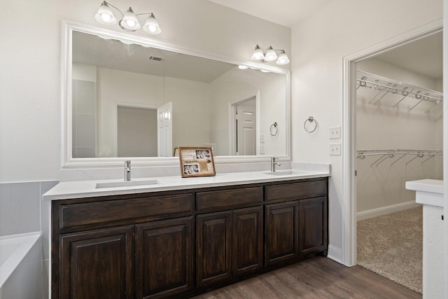 bathroom with vanity, wood-type flooring, and a washtub