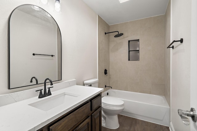 full bathroom featuring hardwood / wood-style flooring, tiled shower / bath, vanity, and toilet