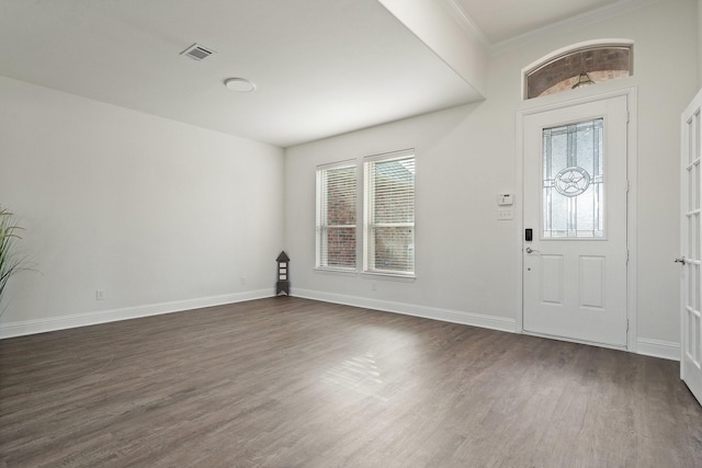 foyer entrance with ornamental molding, dark wood-type flooring, and a wealth of natural light