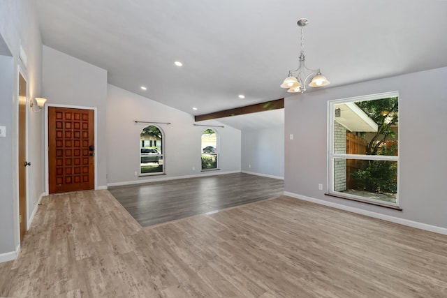 unfurnished living room with vaulted ceiling with beams, light hardwood / wood-style flooring, and a chandelier