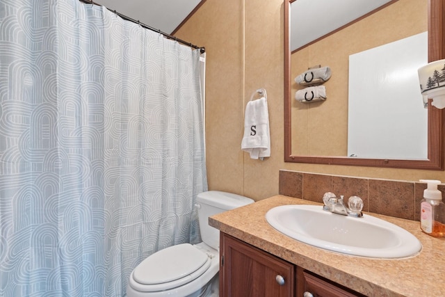 bathroom with ornamental molding, vanity, and toilet