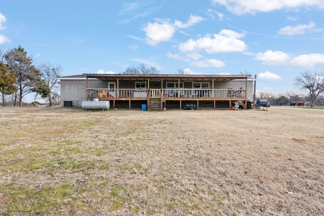 rear view of house with a wooden deck and a lawn