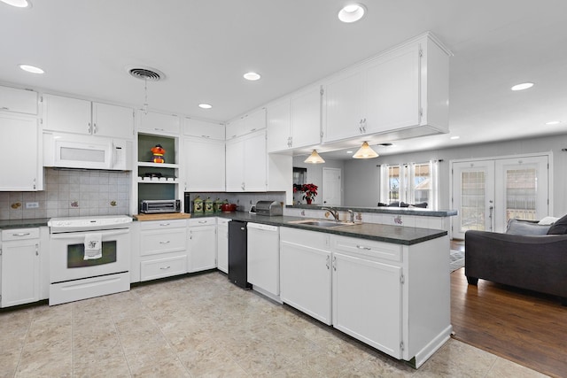 kitchen with french doors, sink, white cabinetry, kitchen peninsula, and white appliances