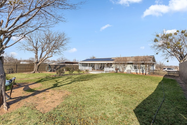 rear view of house with a lawn and solar panels