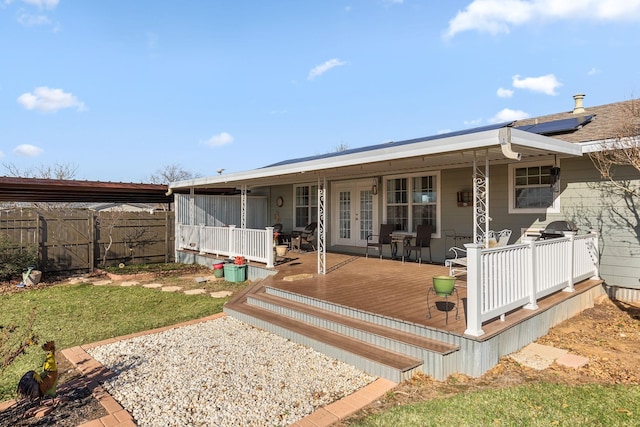 rear view of property with a wooden deck and a yard