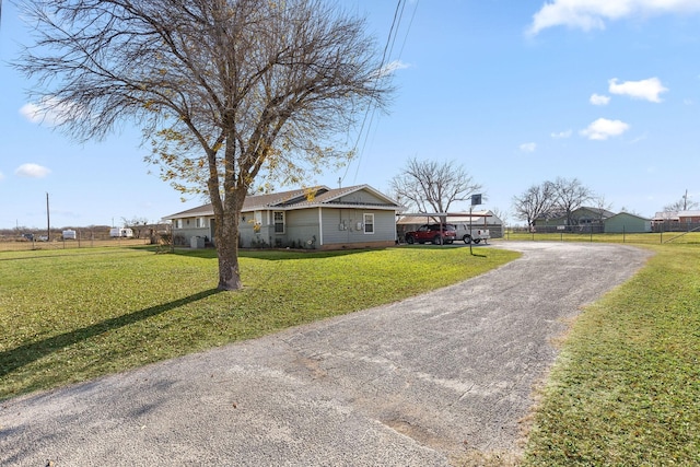 ranch-style home featuring a front lawn and a carport