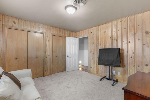 carpeted home office featuring wood walls