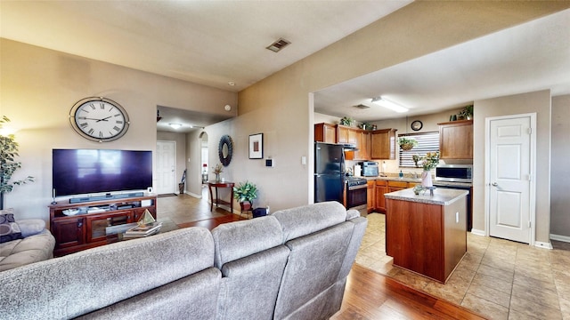 living room with sink and light wood-type flooring