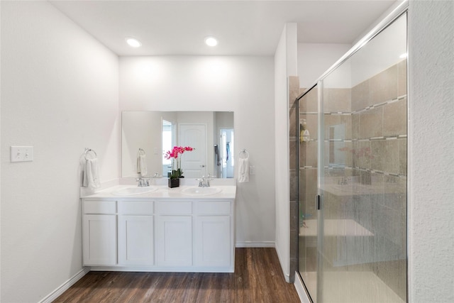 bathroom featuring hardwood / wood-style flooring, vanity, and a shower with shower door