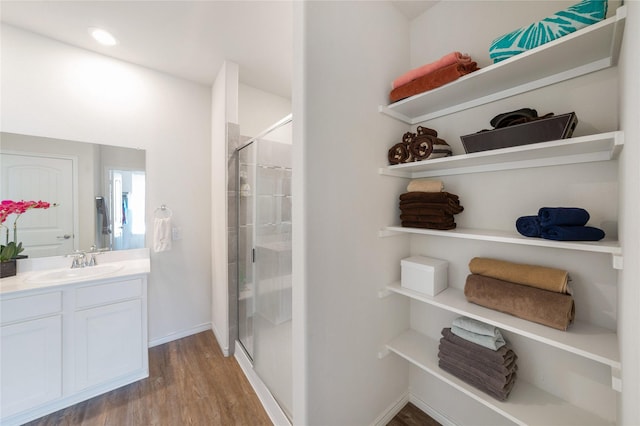 bathroom featuring hardwood / wood-style flooring, vanity, and a shower with door