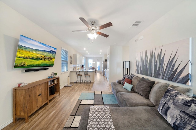 living room with light hardwood / wood-style floors and ceiling fan