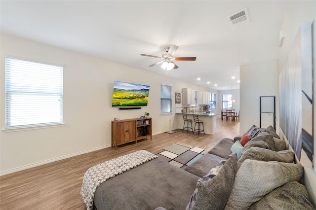 living room with ceiling fan and light hardwood / wood-style floors