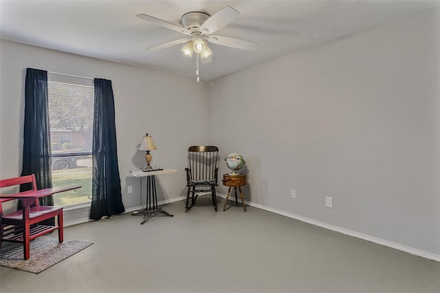 sitting room with concrete floors and ceiling fan