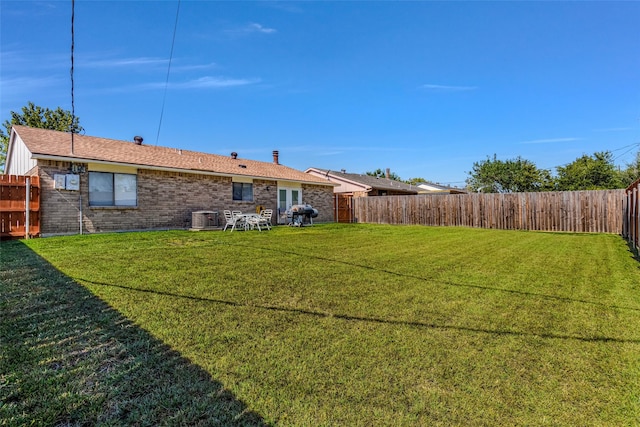 back of house with cooling unit and a lawn