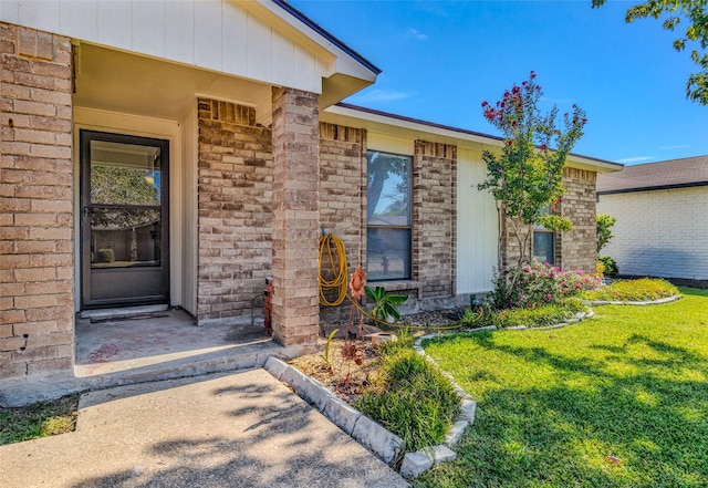 view of exterior entry featuring a yard