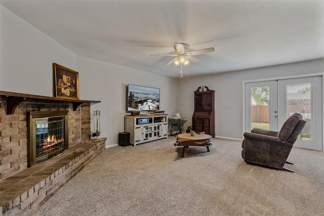 carpeted living room with french doors, ceiling fan, and a brick fireplace